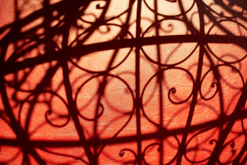 Texture. The shadow of the forged bars on red leather.