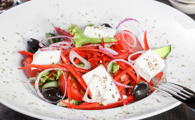 Greek salad of organic vegetables with tomatoes, cucumbers, red onion, olives, feta cheese and...