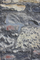 Ancient wall of the medieval city, the wall of an ancient temple in Prague, stone masonry test with cement, blank for designer, background