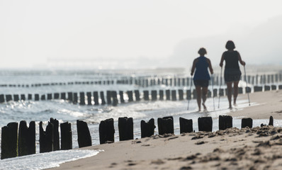 Kolobrzeg, Poland 28 Juli 2018. Misty morning on the Polish beach visible blurred two women...