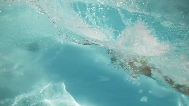 Slow motion, women dive into pool