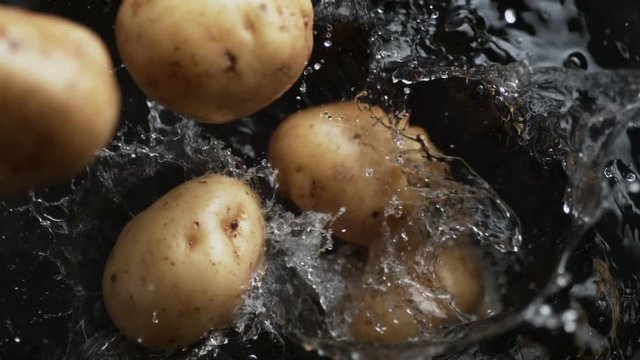 Throwing potato into boiling water. Shot with high speed camera, phantom flex 4K. Slow Motion.