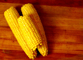 Piled,organic corn on wooden board background 1