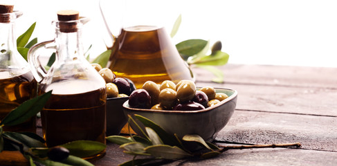 Olives. Bottle virgin olive oil and oil in a bowl with some olives