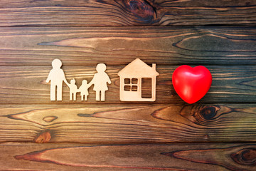 family, house, heart on a wooden background. family values. the property.