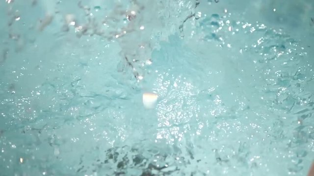 Slow motion close up, pineapple falls into pool