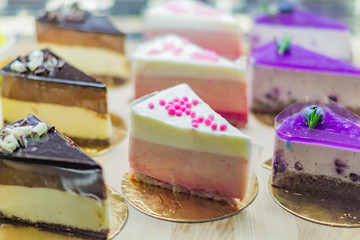 Pastry shop display window with variety of cheesecakes, selective focus