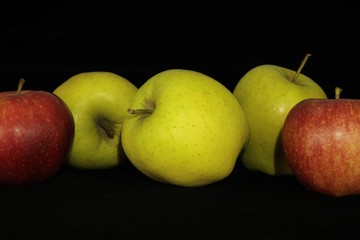 Single or group of apples including granny smith, golden delicious and royal gala on a black background.
