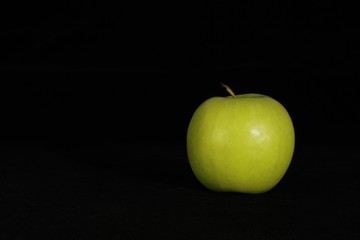 Single or group of apples including granny smith, golden delicious and royal gala on a black background.