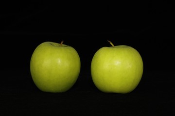 Single or group of apples including granny smith, golden delicious and royal gala on a black background.