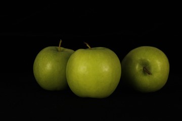 Single or group of apples including granny smith, golden delicious and royal gala on a black background.
