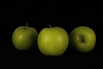 Single or group of apples including granny smith, golden delicious and royal gala on a black background.