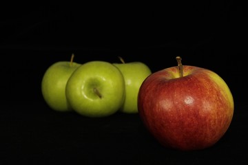 Single or group of apples including granny smith, golden delicious and royal gala on a black background.