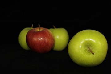 Single or group of apples including granny smith, golden delicious and royal gala on a black background.