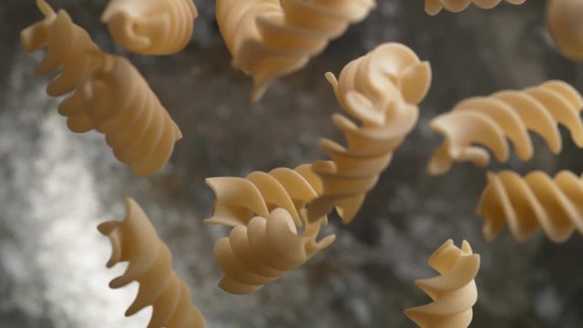 Camera follows throwing fusilli spiral pasta into water. Overhead shot. Shot with high speed camera, phantom flex 4K. Slow Motion.