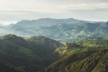 morning mist in the mountain peaks on natural landscape. Green valley on background foggy dramatic sky. Panorama horizon perspective view of scenery hills mountain tops. Travel mockup concept