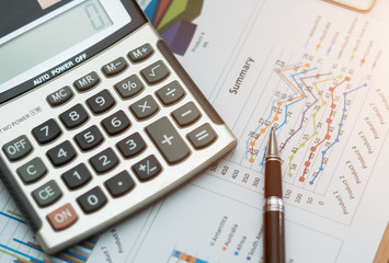 Top view,Close up business concept, Pen is on summary report and calculator on table office.