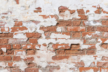 Ancient red brick wall covered by white plaster old church russia background