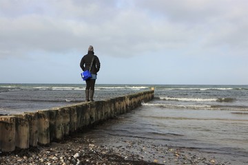 Frau steht allein am Meer und sieht sorgenvoll in die Zukunft, Konzept Trennung, Beziehung Schmerz