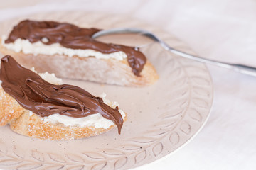 Two slices of bread with mascarpone cheese and chocolate cream.