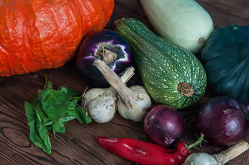 Autumn harvest of fruits and vegetables: pumpkin, eggplant, patisson, pepper, onion, garlic on wooden background