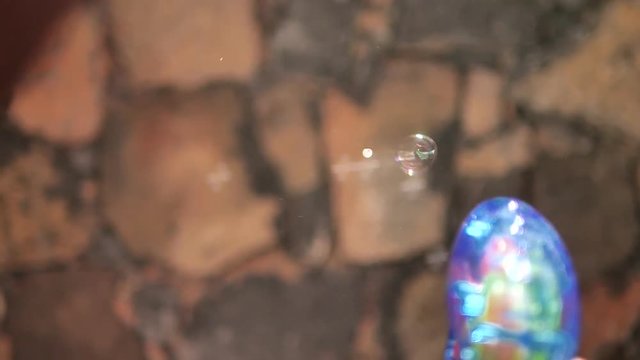 Person shoots bubble gun, slow motion close up