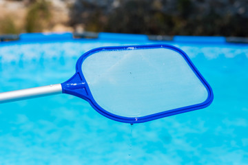 Backyard garden swimming pool cleaning close up
