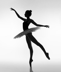 A young ballerina in a ballet tutu and on pointe. Black and white photo.