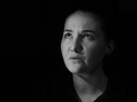 M&auml;dchen im dunkeln Raum schaut nach oben