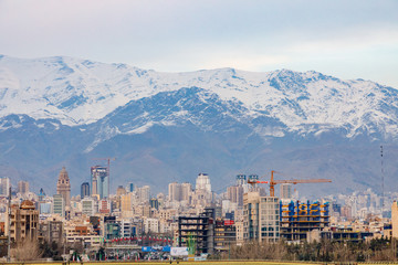 Fototapeta na wymiar Islamic Republic of Iran. Tehran city center and mountainous background. Freeway with flags. 02 March 2018