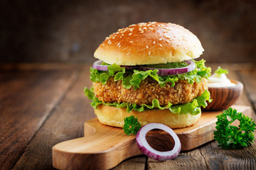 Fresh tasty chicken burger on wood table. - obrazy, fototapety, plakaty