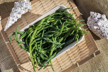 Salicornia sea beans in sunlight on wooden table