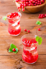 Cold compote with ice cubes from fresh red currant berries. Boiled redcurrant juice.