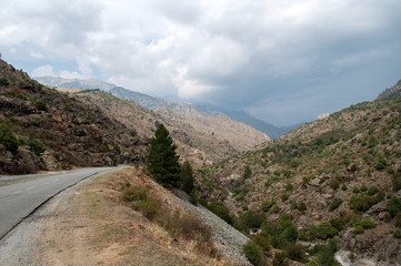 Fototapeta premium A mountain road in an arid stony landscape in the middle of the island of Corsica