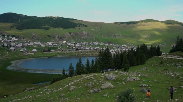 Man and woman looking at the lake and village in the distance - (4K)