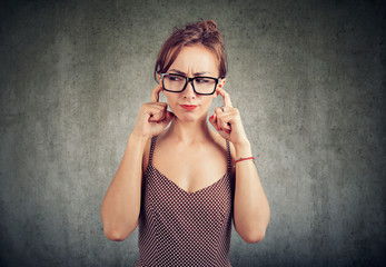 Annoyed young woman covering ears