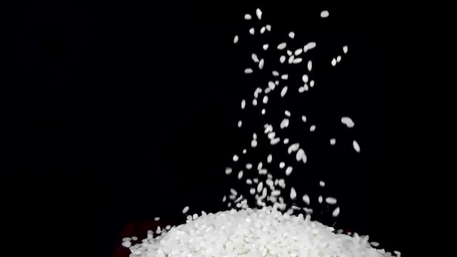 slow motion of falling rice on black background on the pile 240