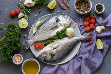 Raw dorado fish with spices cooking on cutting board