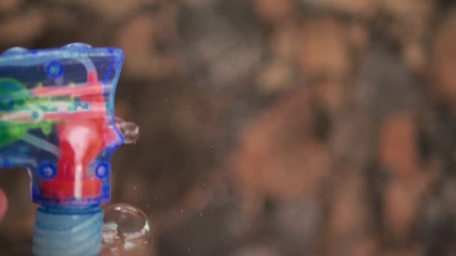 Shooting bubble gun in slow motion, close up
