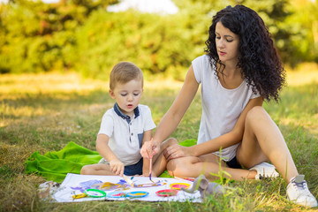 Fototapeta premium Mother and son draw outdoor. Concept of happy family