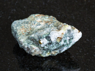 Chrysoberyl crystals in raw beryl rock on black