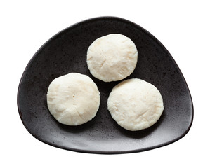 Fototapeta na wymiar Idli Sambar dumplings on black plate isolated