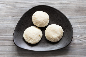 Idli Sambar dumplings on black plate on table