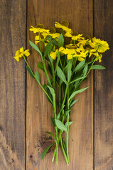 Bouquet with yellow flowers on wooden table