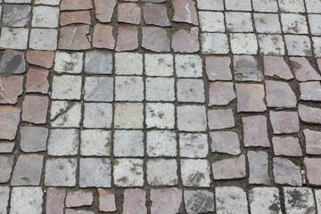 Cobbles close-up. An ancient road lined with a stone in Prague. Texture of smooth stones. Background old stone road in the city. Pattern with natural material