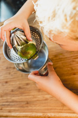 Child squeezing the juice of a lemon.