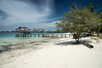 Tropical sand beach resort on remote Malenge island, part of Togean archipelago with traditional boats, Lestari, Indonesia