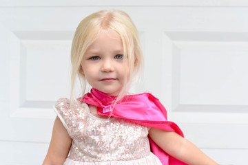 Cute little blonde girl playing in dress up clothes