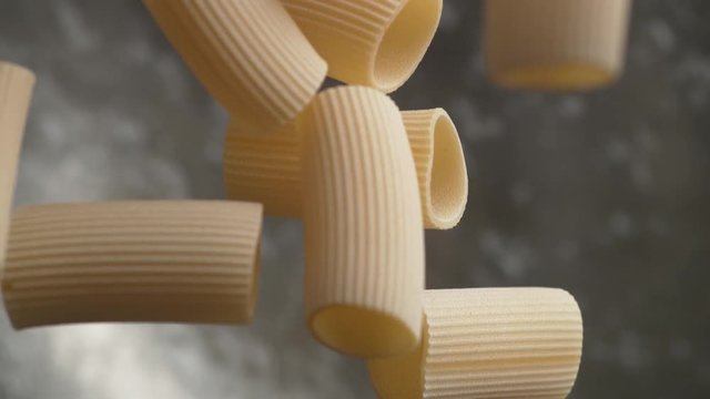Camera follows throwing rigatoni pasta into water. Overhead shot. Shot with high speed camera, phantom flex 4K. Slow Motion.