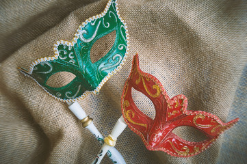 Closeup red and green carnival masquerade, venetian mask place on the burlap sackcloth, Top view